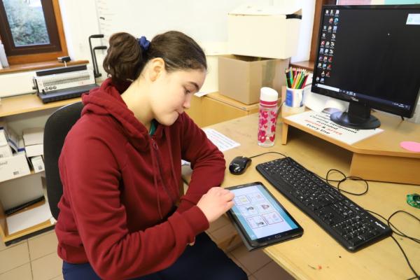 Photo of woman sitting down using a tablet